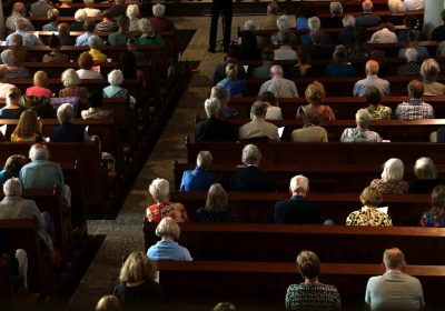 Audience listening attentively during a funeral speech.