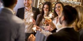 People enjoying a lively party with speeches and sparklers, celebrating together.