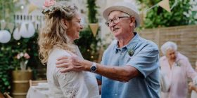 Elderly man giving a heartfelt speech at a wedding reception.