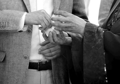 Couple exchanging wedding rings during vows at a wedding.